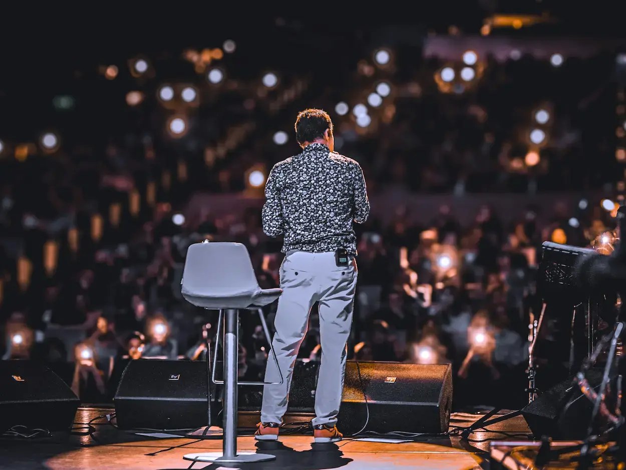 person singing on stage in front of audience