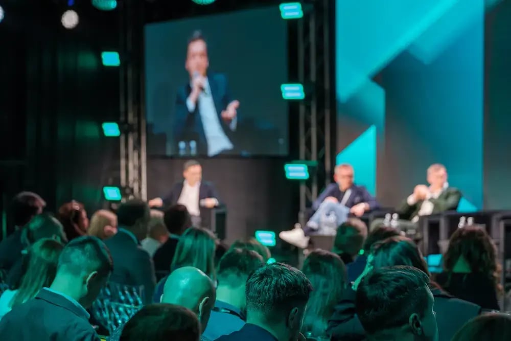 Two speakers in conversation on stage in front of a seated audience