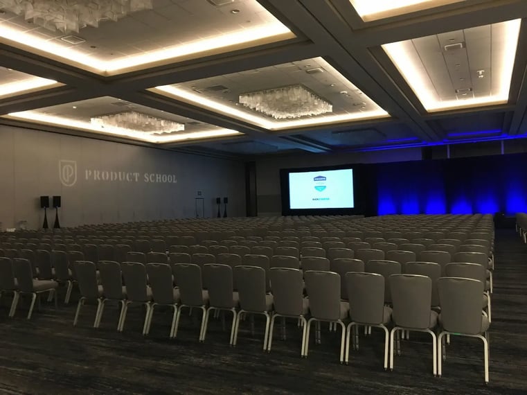 Conference room set with projection screen and rows of audience seating