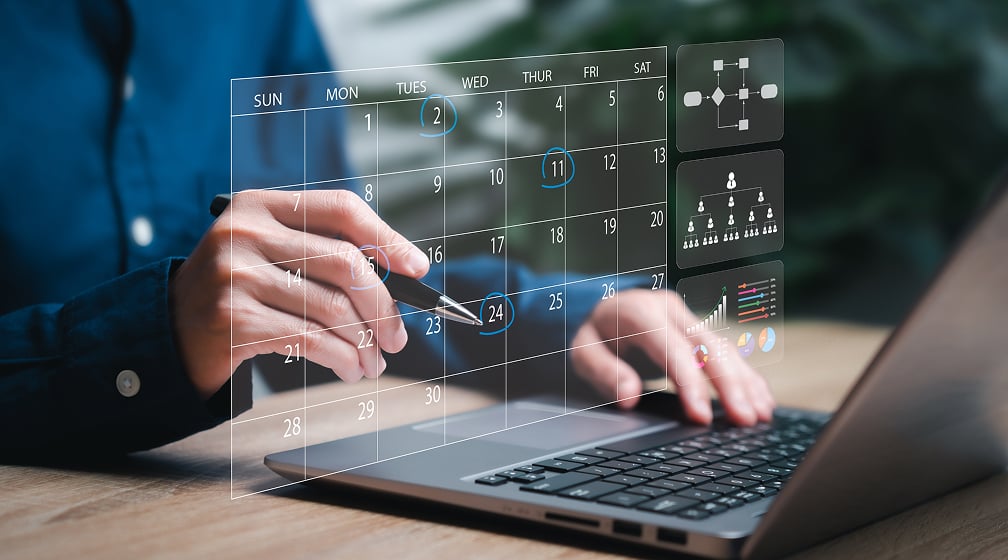 hands on laptop computer with calendar for planning