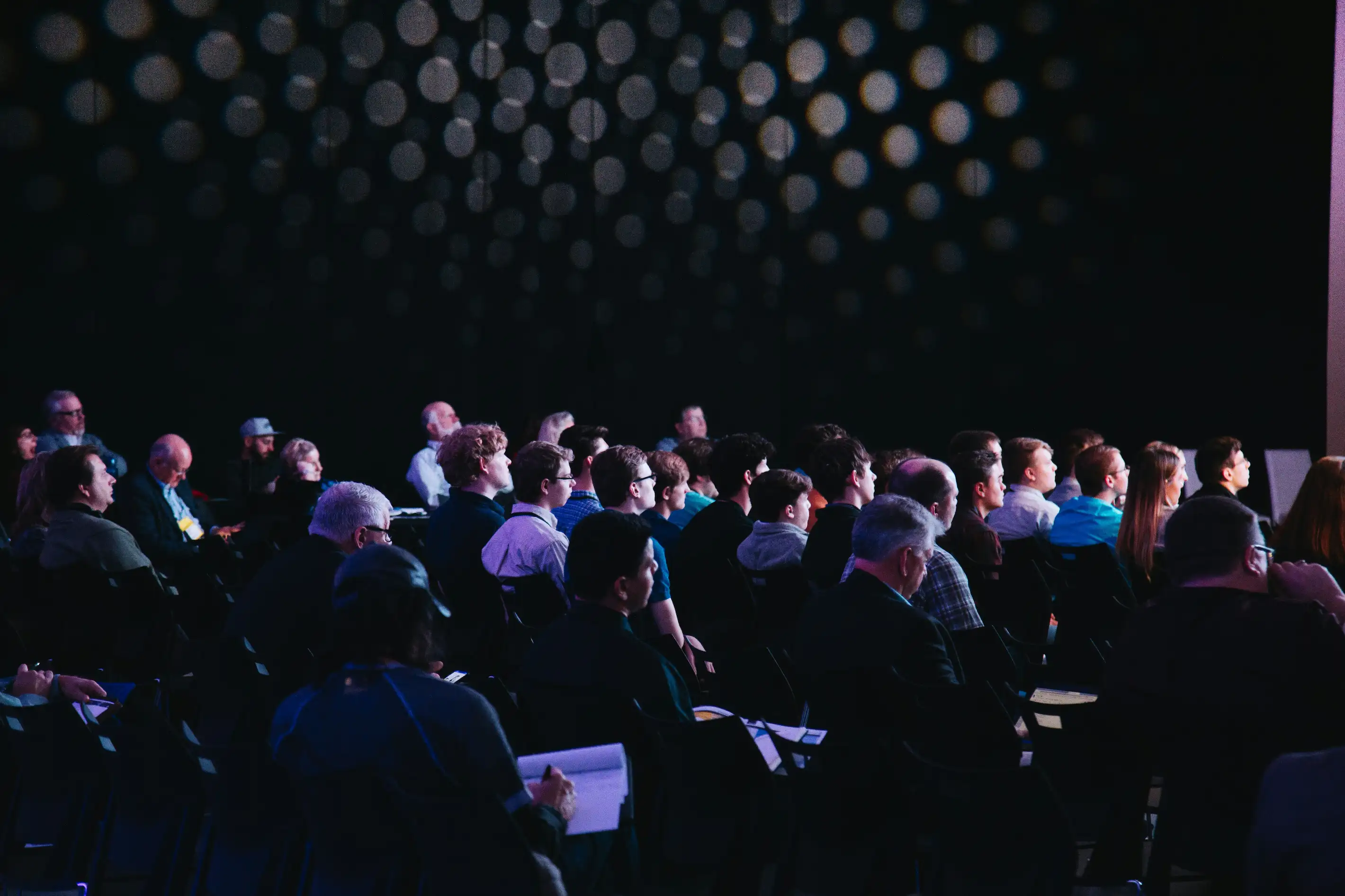 Audience seated in front of a large event screen