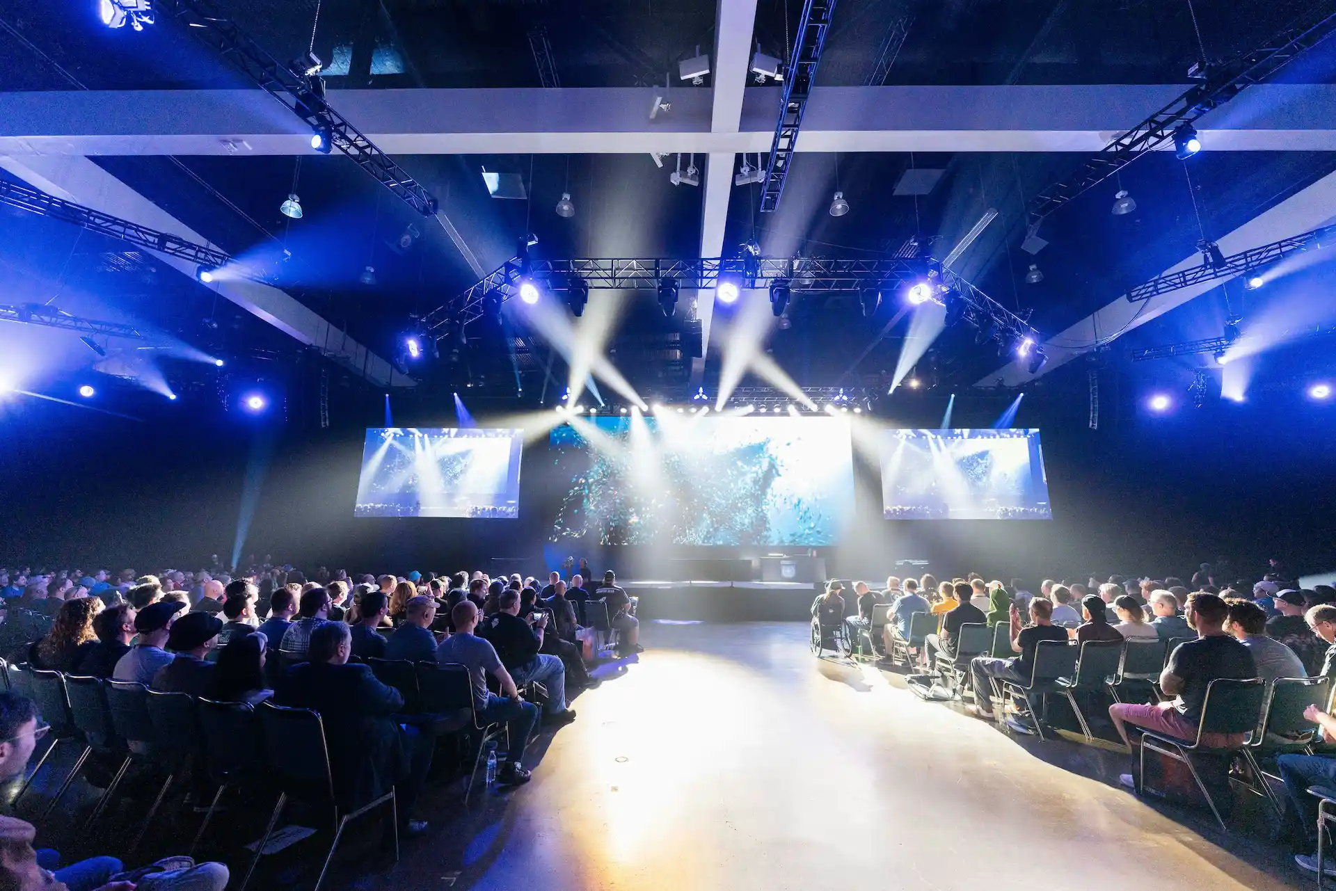 Audience watching a large stage presentation at a professionally produced town hall